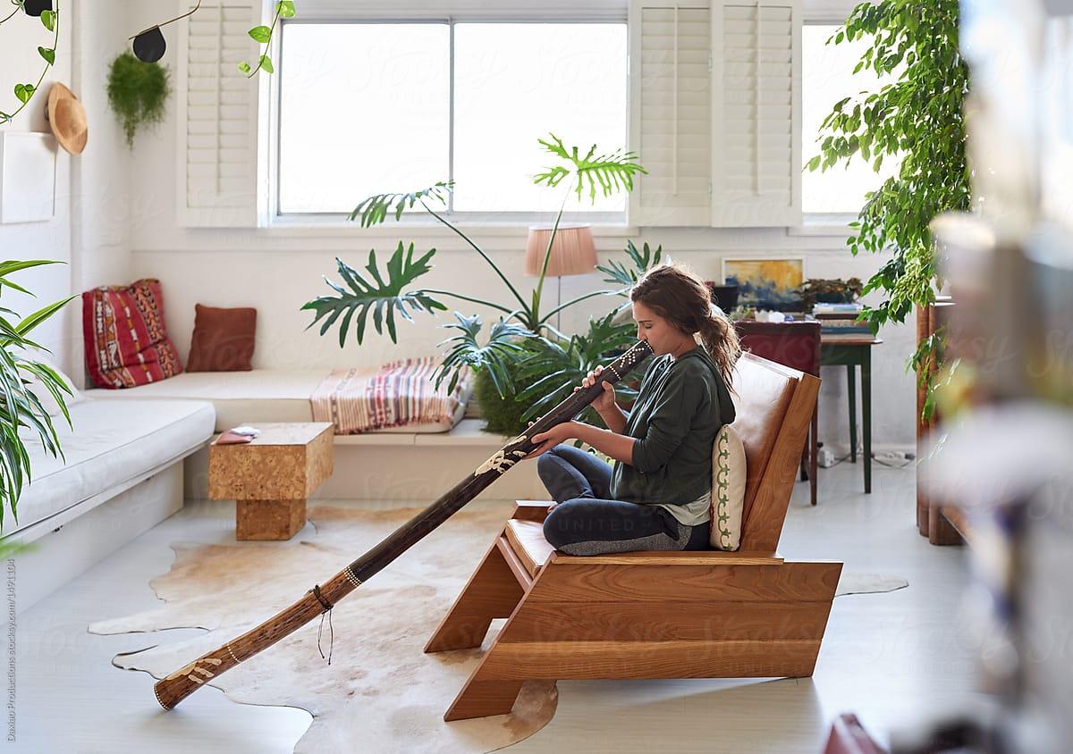 Hippy Woman Playing Didgeridoo At Home